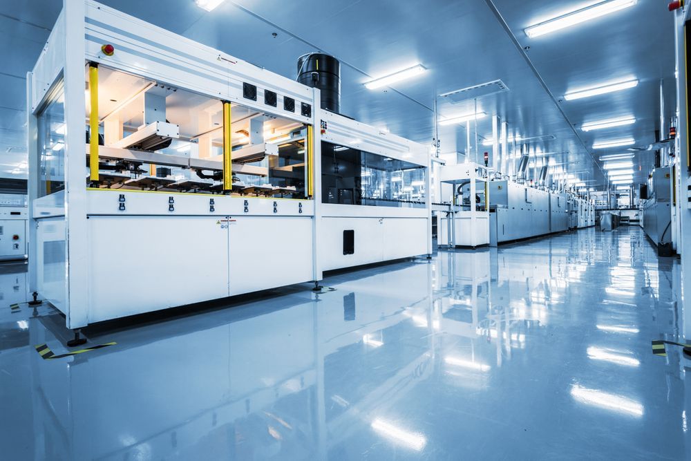 Production line in an empty, gleaming white lab.
